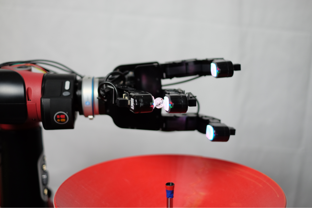 A robotic arm picks up a marble using the DIGIT Sensor
